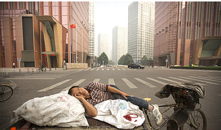 중국 남성이 6일 베이징 대로 한 복판에서 자전거를 개조한 수레 위에 누워 잠을 자고 있다. 2015.10.06