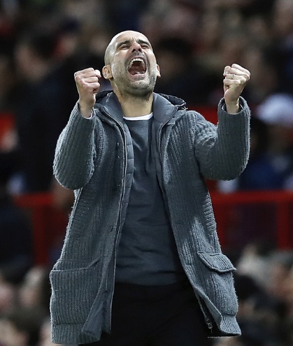 Manchester City manager Pep Guardiola celebrates his side's second goal during the English Premier League soccer match between Manchester United and Manchester City at Old Trafford Stadium in Manchester, England, Wednesday April 24, 2019.(Martin Rickett, PA via AP)