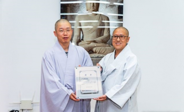 미타사 주지 희원스님(오른쪽)이 한국불교문화사업단 사무국장 우석스님으로부터 템플스테이 운영사찰 증서를 수여받고 있다.(사진=한국불교문화사업당 제공)2020.04.16.