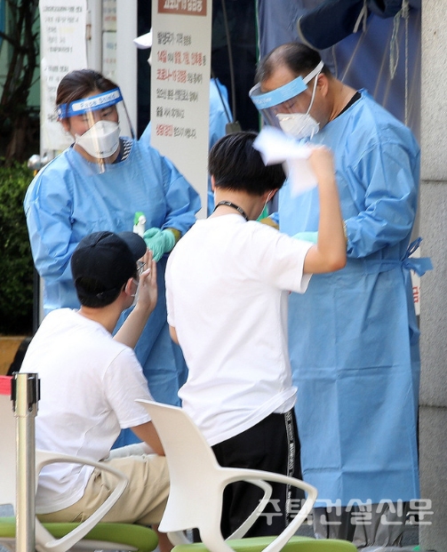 수도권에 폭염주의보가 발령된 22일 오후 서울 구로구보건소에 마련된 선별진료소에서 한 시민이 종이로 부채질을 하며 진료를 대기하고 있다. 2020.06.22.
