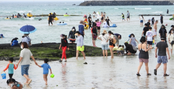 장마가 소강상태를 보이는 11일 오후 제주시 한림읍 협재해수욕장을 찾은 피서객들이 물놀이를 하며 더위를 식히고 있다. 2021.07.11